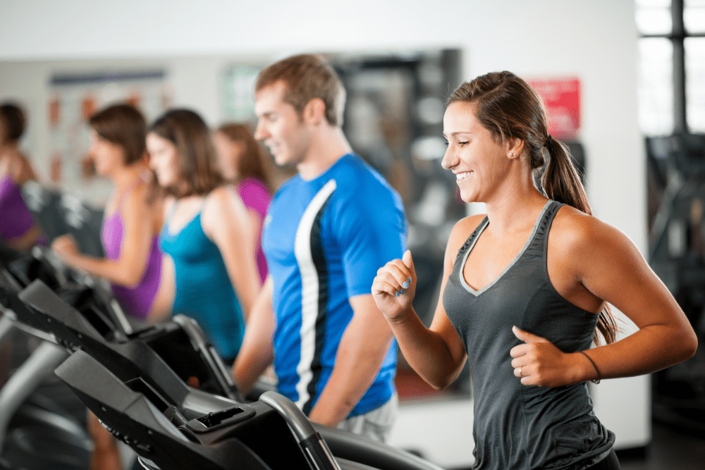 Gym members training on treadmills